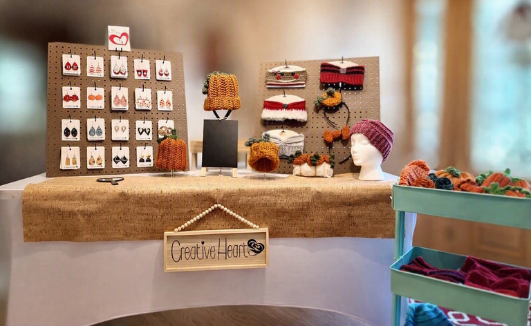 Creative Heart Jewelry display table with handmade earrings, knit hats, and headbands